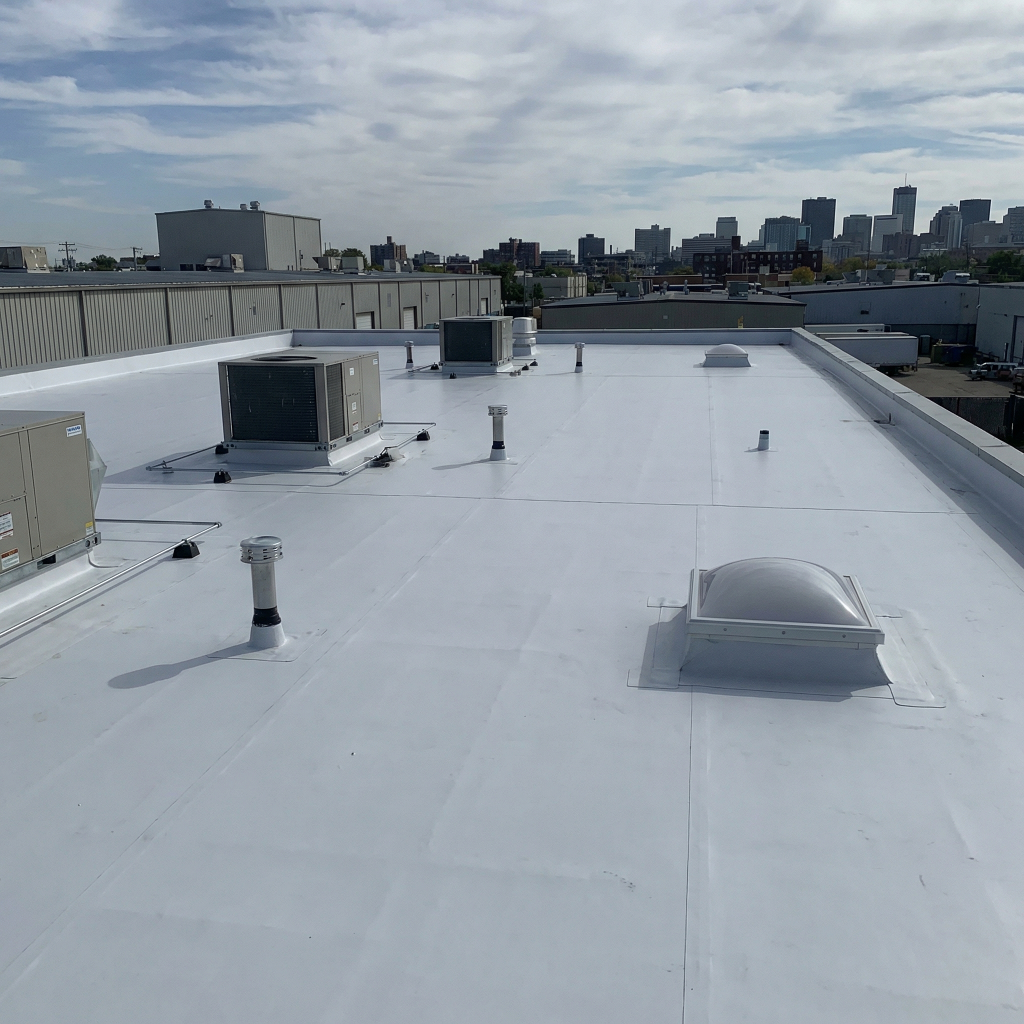 White commercial TPO roof with rooftop equipment and skylight
